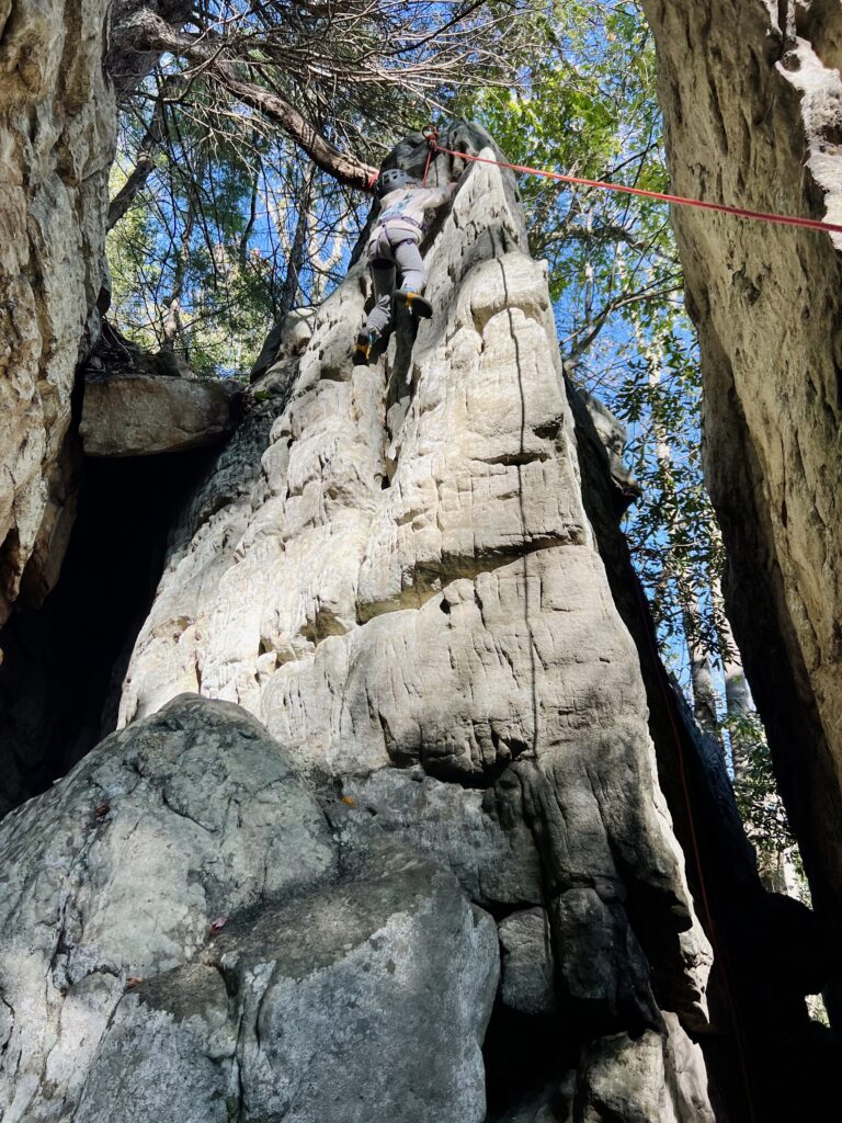 Little girl rock climber on sandstone cliffs in New River Gorge National Park