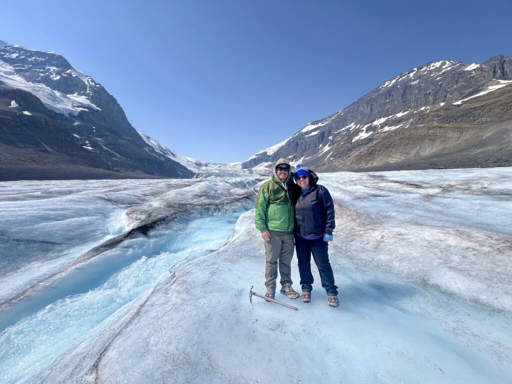 couple hiking on athabasca glacier with guide in banff national park